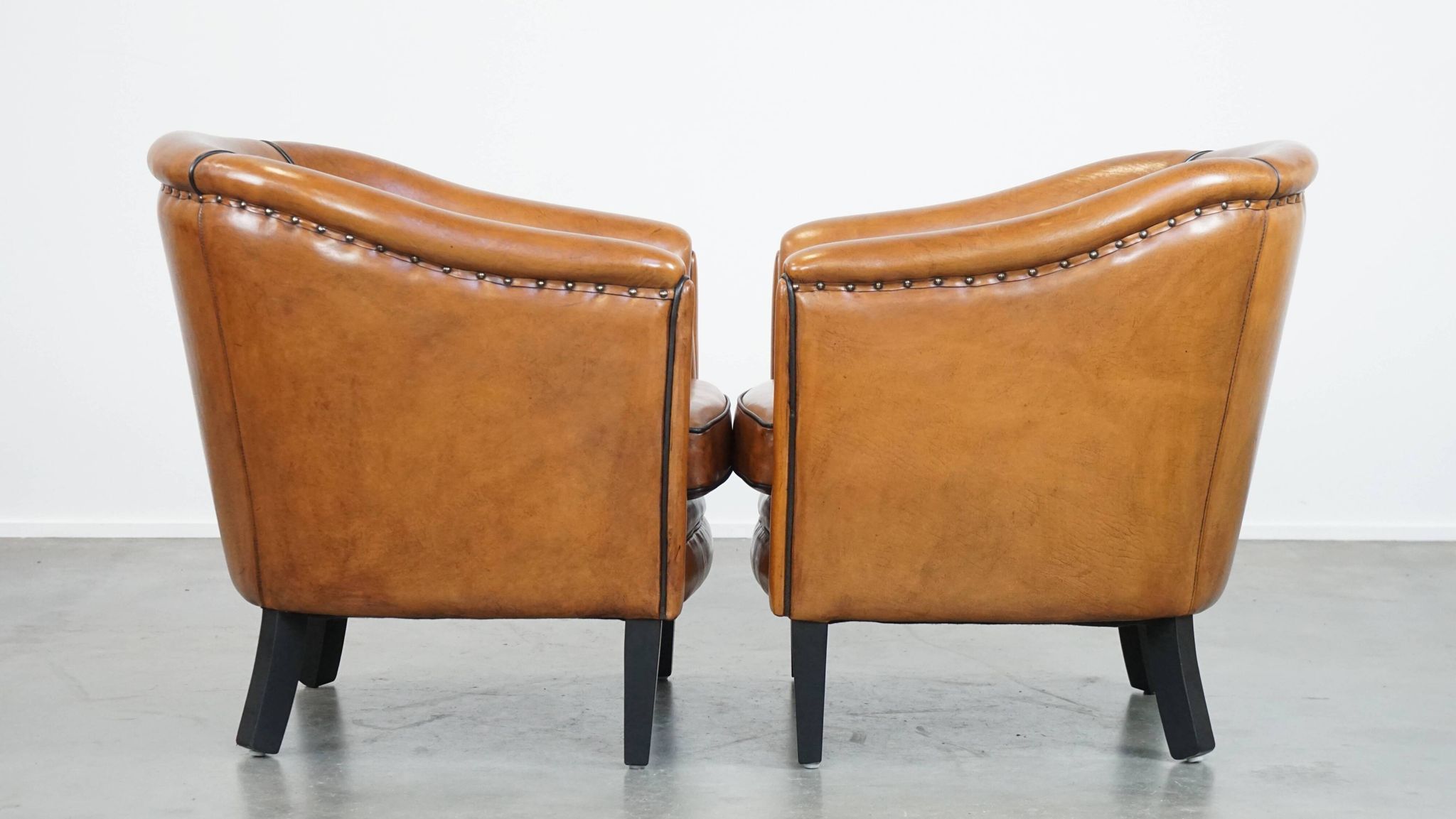 Set of 2 sheep leather club chairs finished with black piping