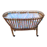 Vintage rattan bed on wheels cradle