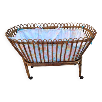 Vintage rattan bed on wheels cradle