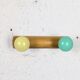 Vintage wall coat rack with 2 yellow and green balls.