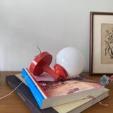 Red plastic wall light with a white opaline glass globe.