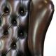 Chesterfield wing chair in dark brown leather with a luxurious appearance