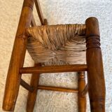 Old, rustic children's chair, small wooden and straw chair.