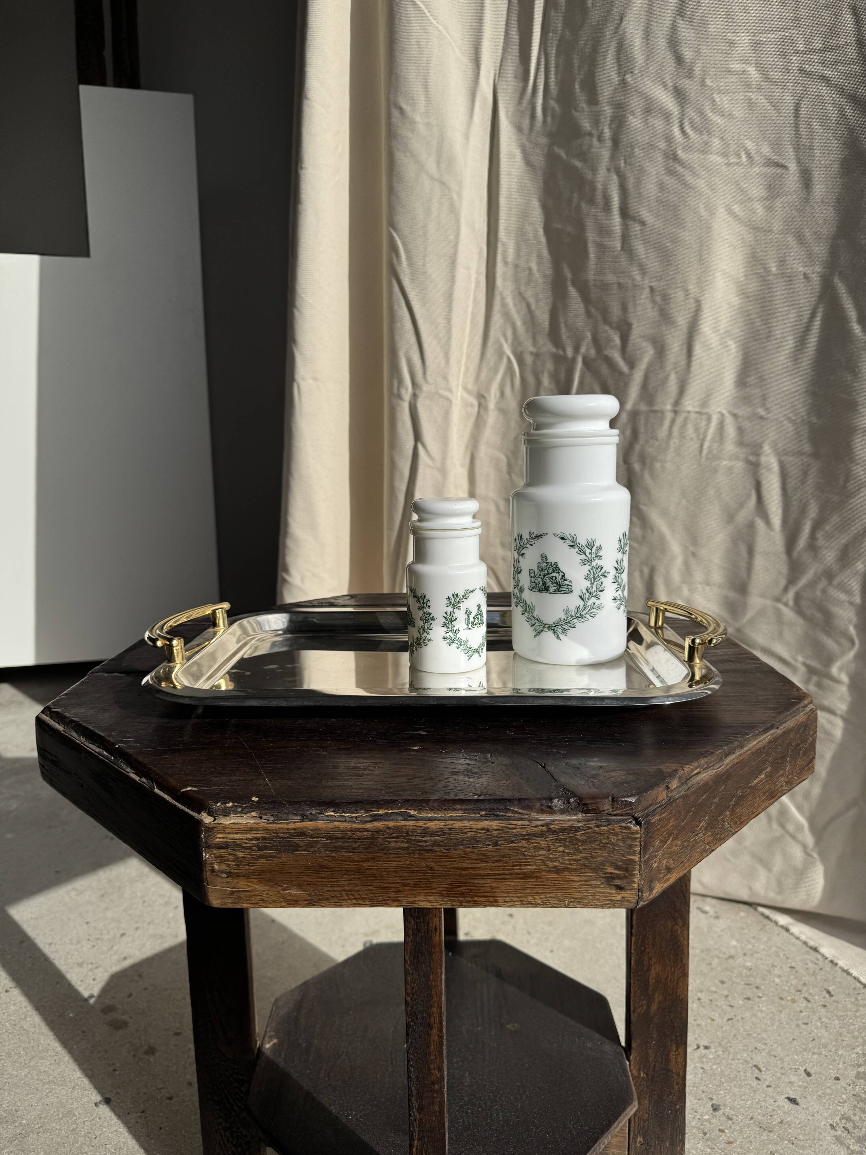 A pair of white glass bottles with Italian green patterns.