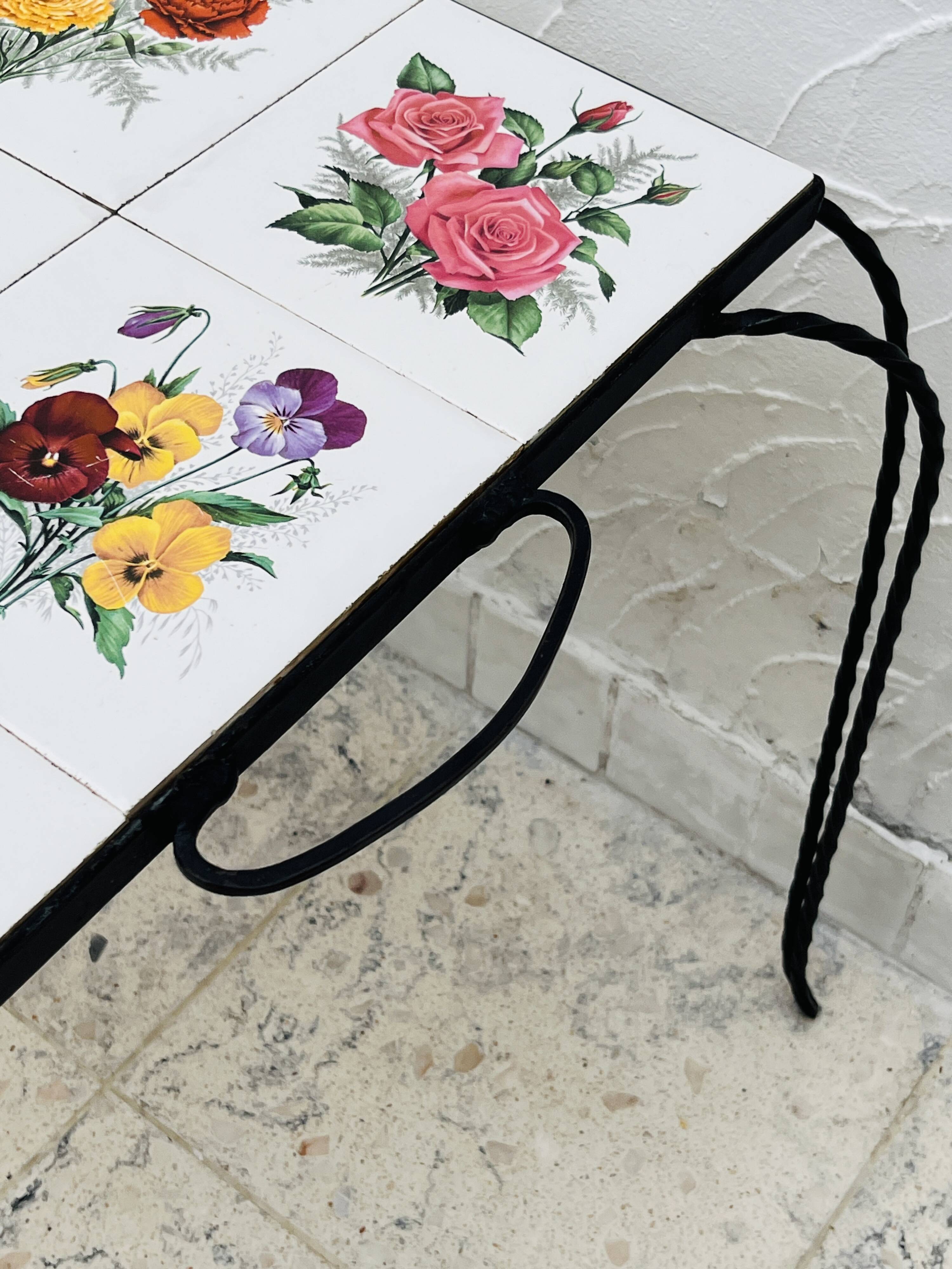 Vintage coffee table in wrought iron with floral tiles.