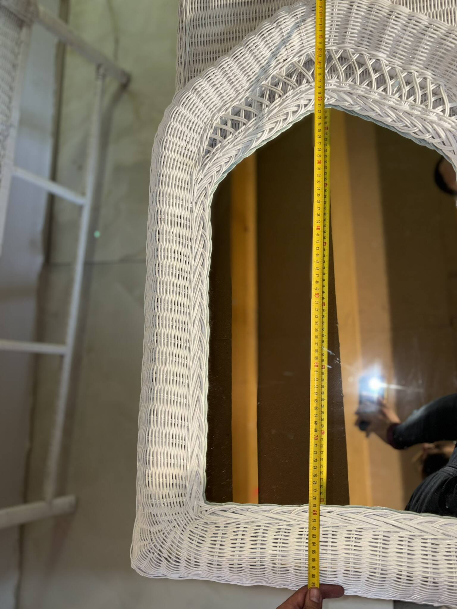 Vintage white rattan mirror with a gothic frame.