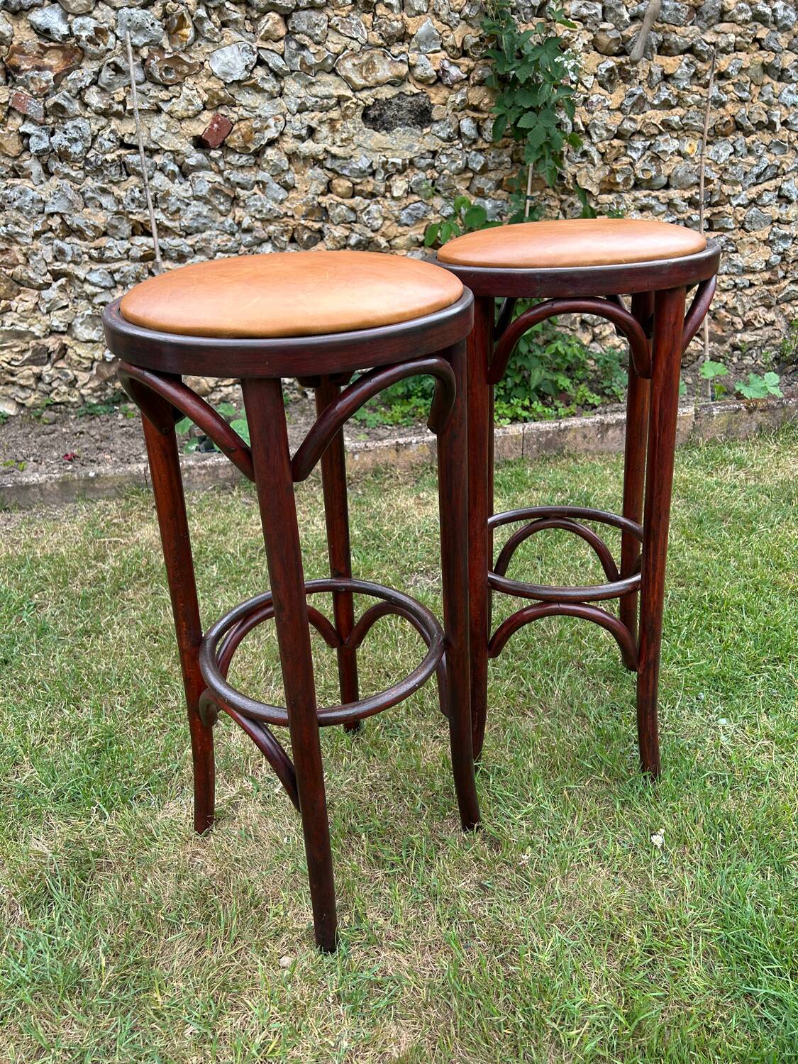 Pair of curved wooden bistro stools with leather seats
