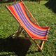 vintage wooden deck chair with red, blue, and yellow striped fabric