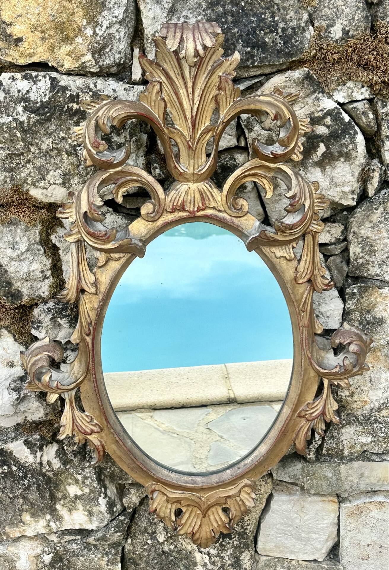 Miroir en bois doré sculpté .