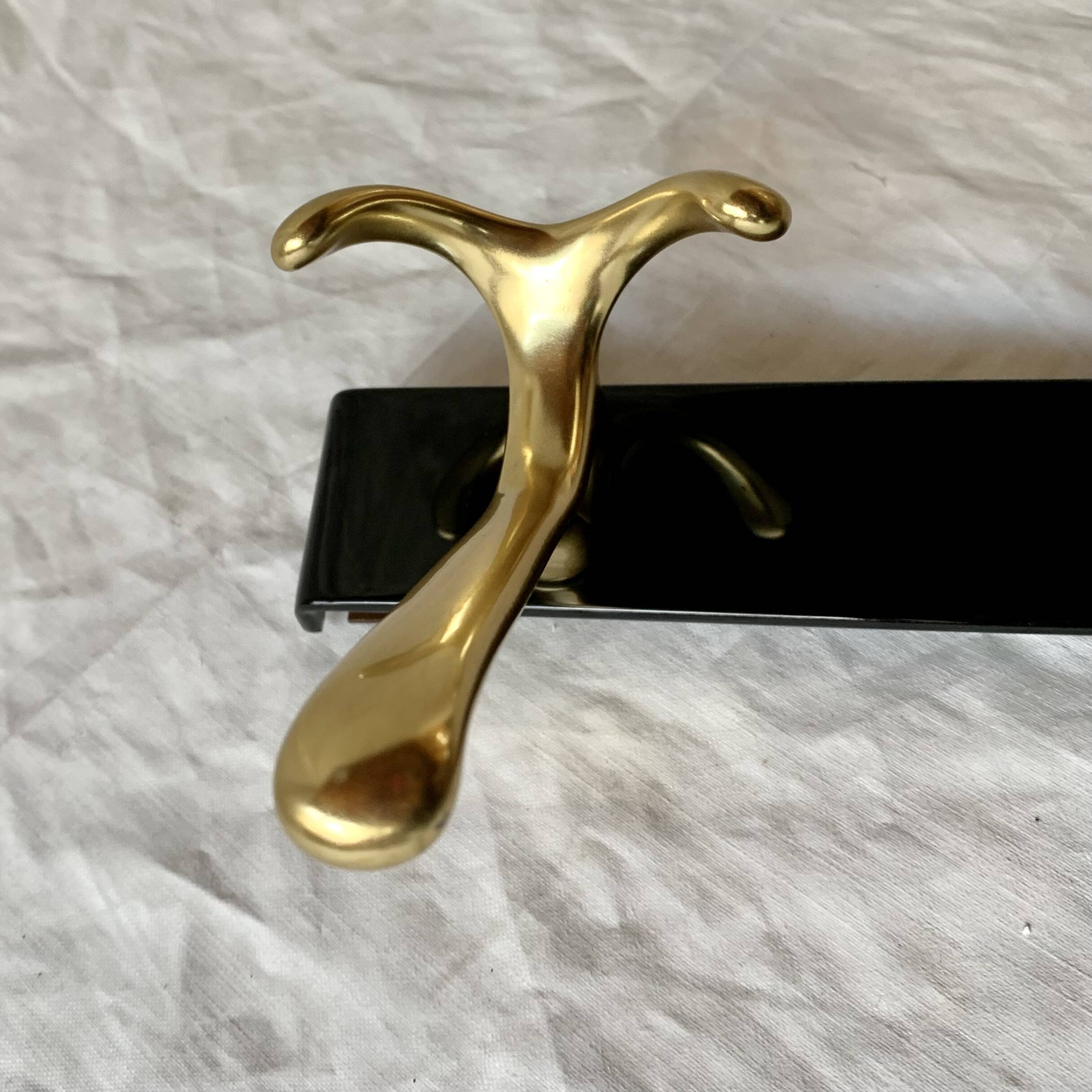 Vintage coat rack in lacquered metal with three golden aluminum hooks