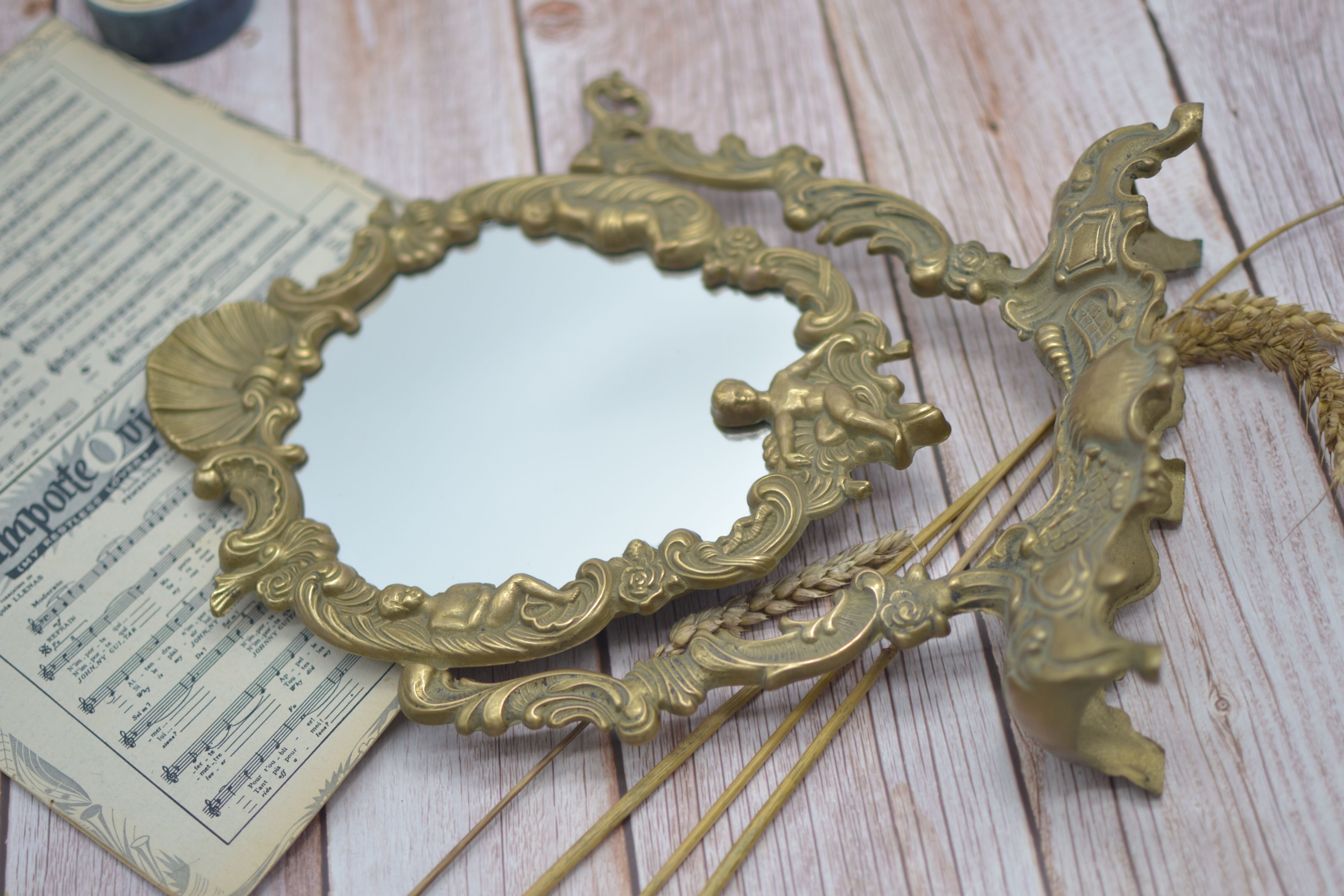Adjustable psyche mirror of 33 centimeters in gilded bronze with angel ornament