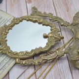 Adjustable psyche mirror of 33 centimeters in gilded bronze with angel ornament