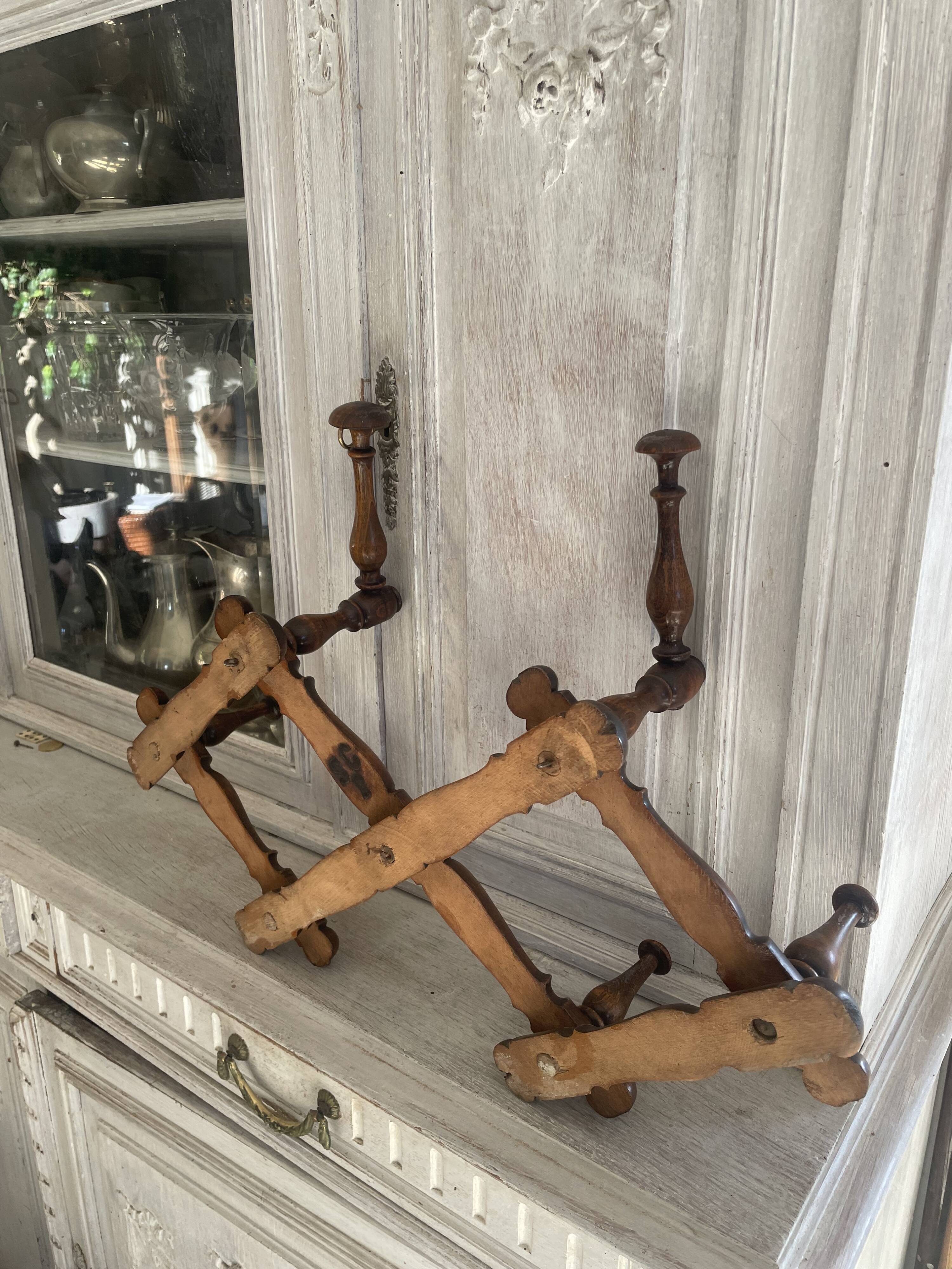 Wall-mounted accordion coat rack made of turned wood