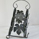 Vintage black wrought iron bottle holder decorated with vine leaves