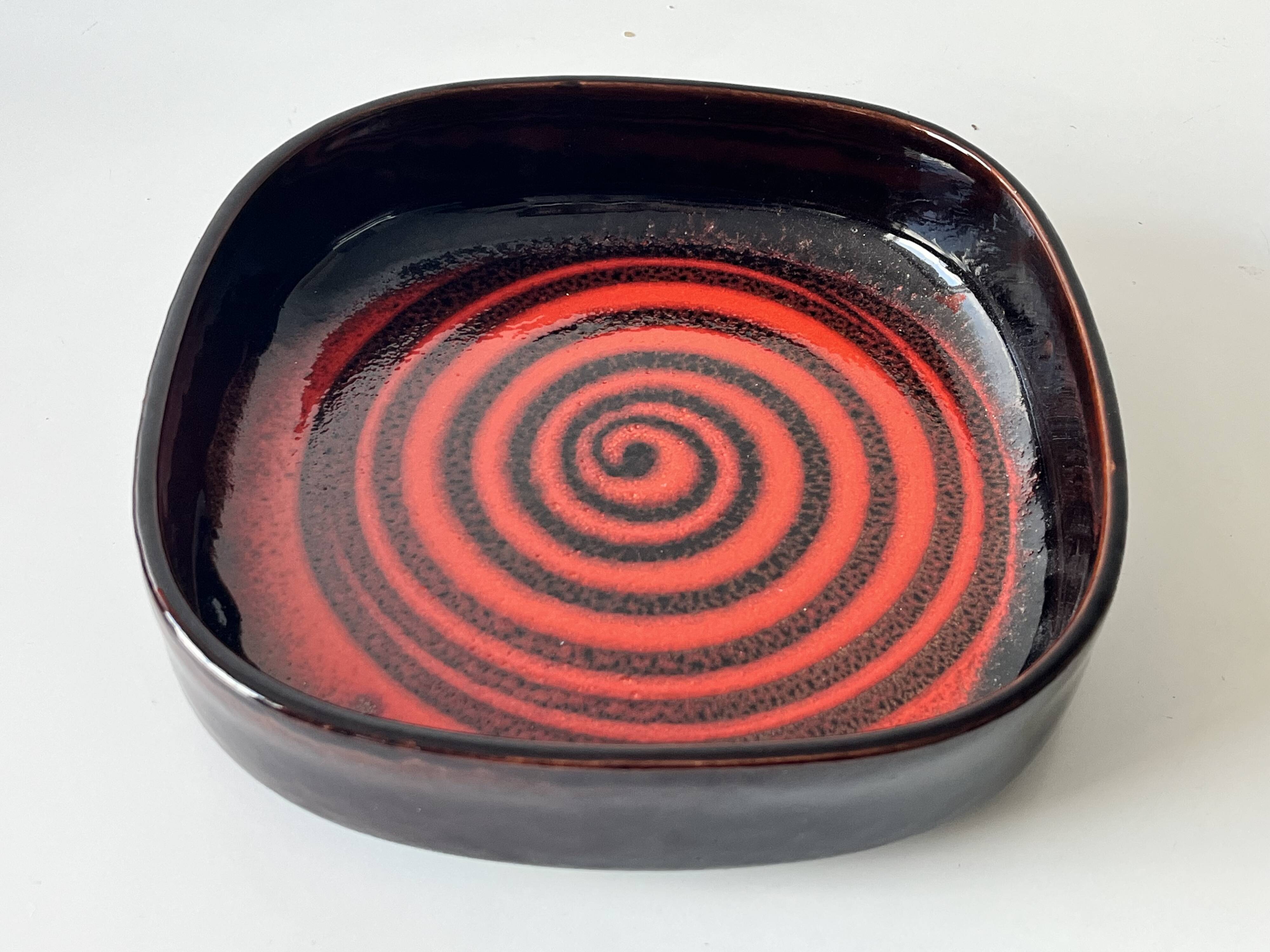 Large decorative ceramic catchall with red and black spiral pattern.