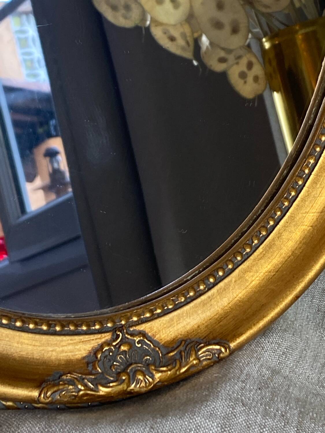 Oval-shaped gilded wooden mirror