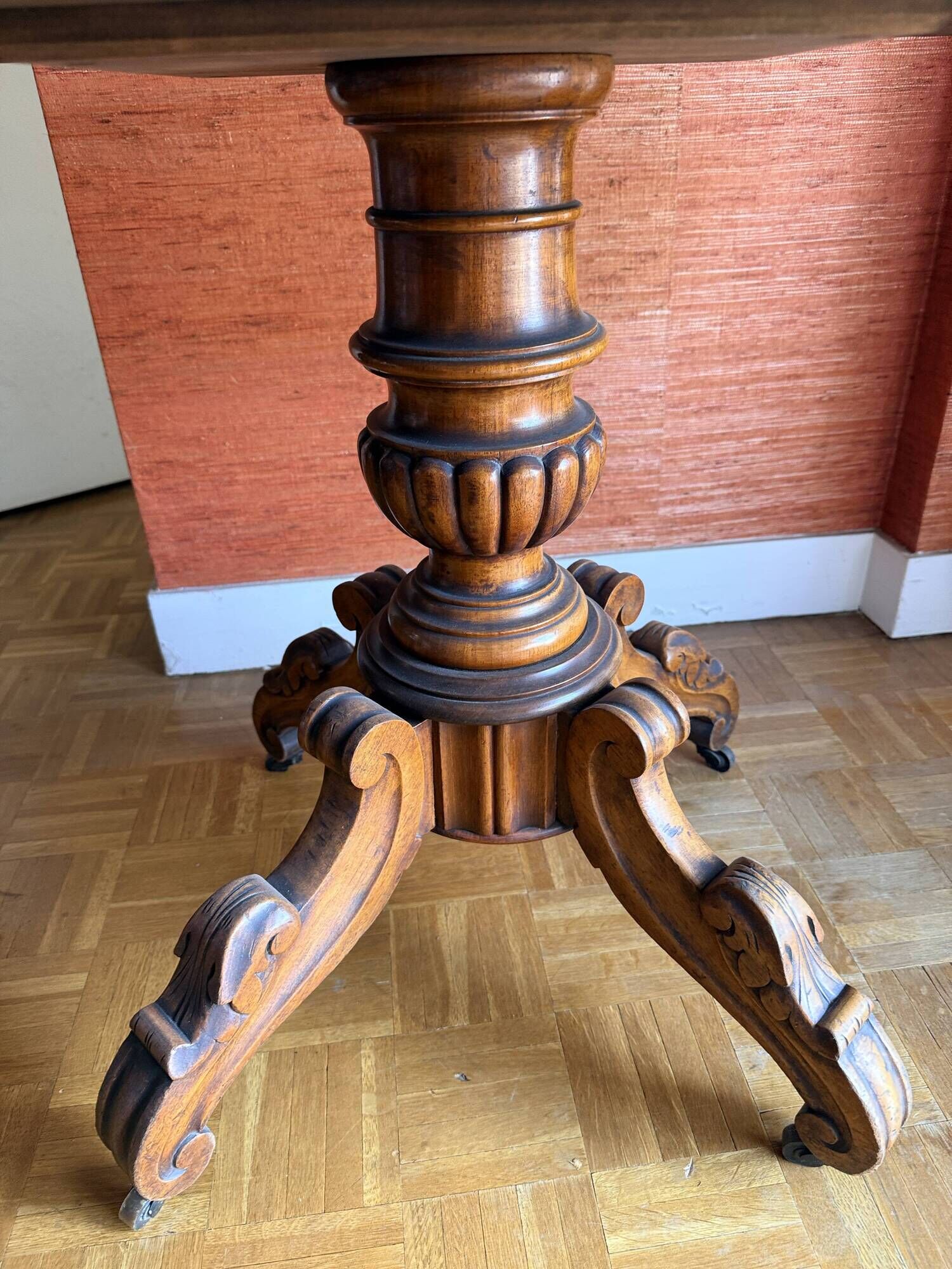 Antique mahogany table with a scalloped top and a sculpted central leg.