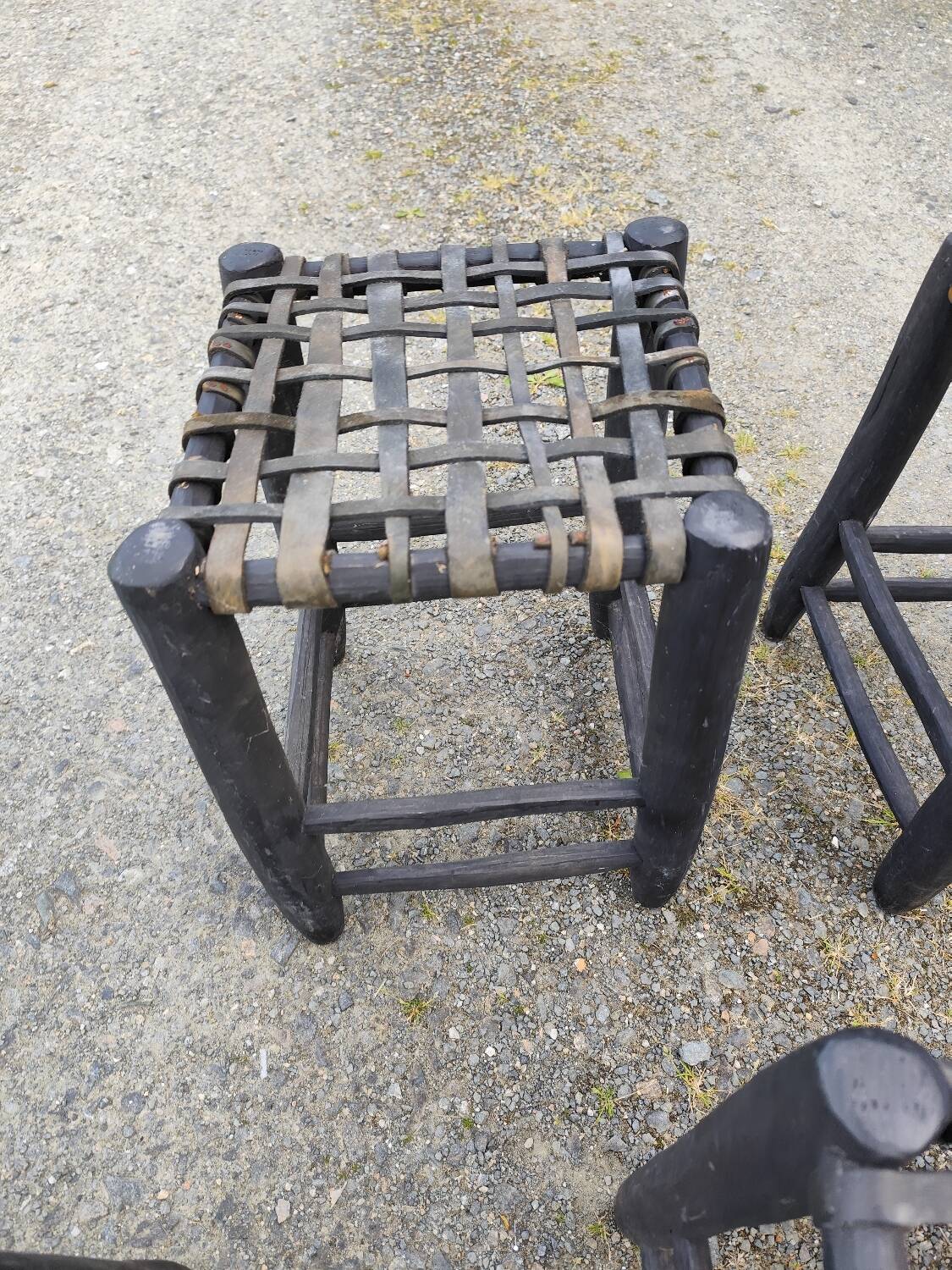 5 blackened wooden stools with woven leather seats by Nina Kaufmann