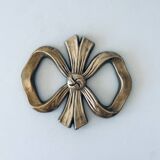 Bow-shaped brass trivet
