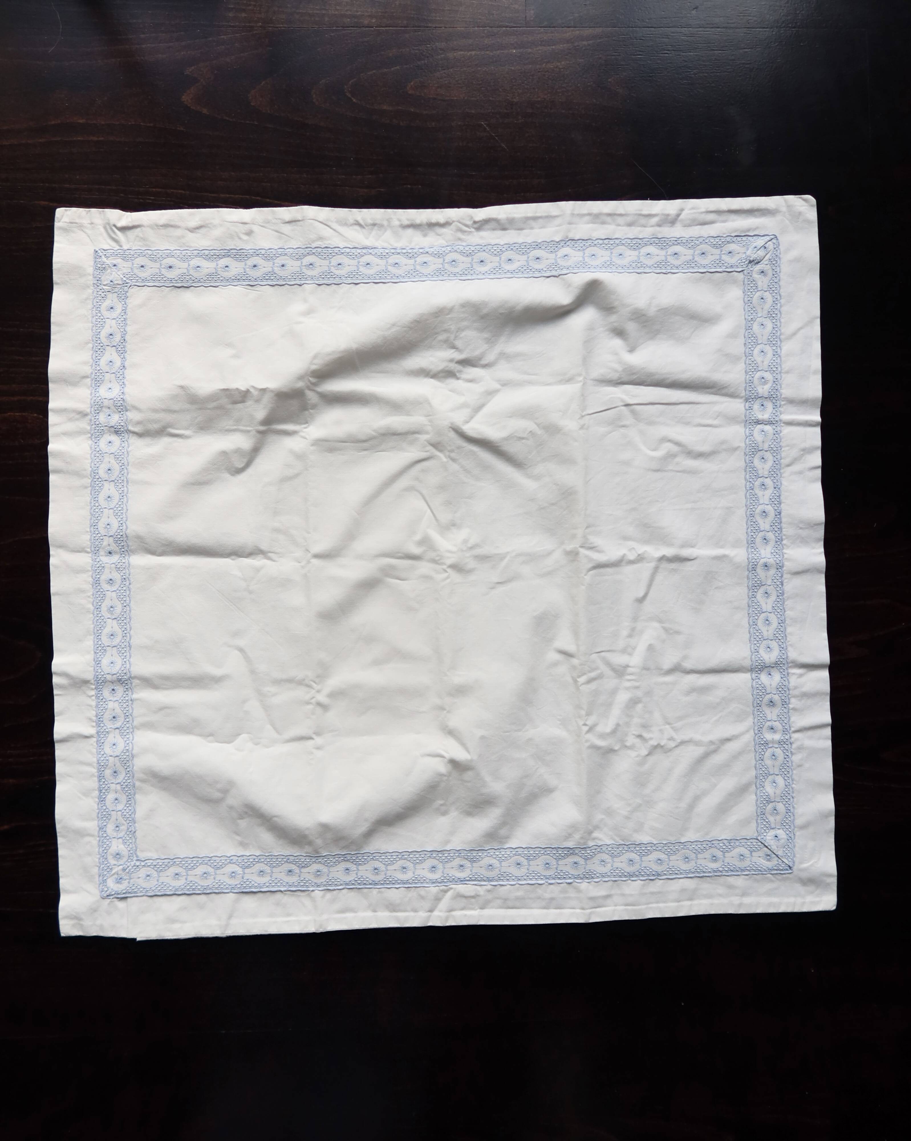 Vintage embroidered pillowcase with light blue thread.
