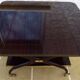 Chic serving table on wheels from the 60s with brass decorations and two shelves.