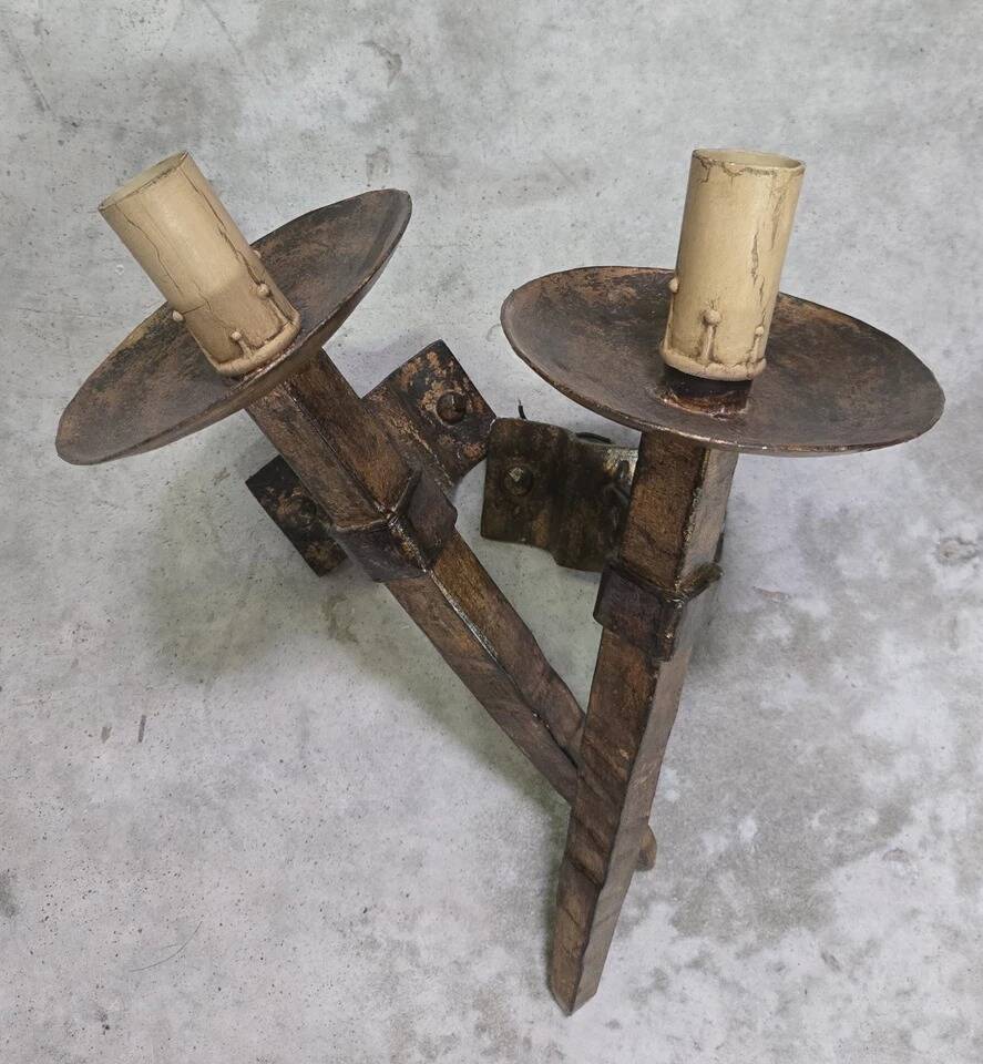 Pair of brutalist wall sconces in hammered and patinated iron, work from the years.