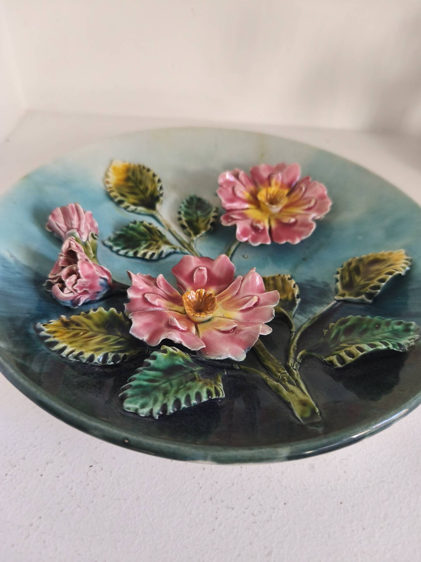 Decorative plate with relief floral pattern in majolica.