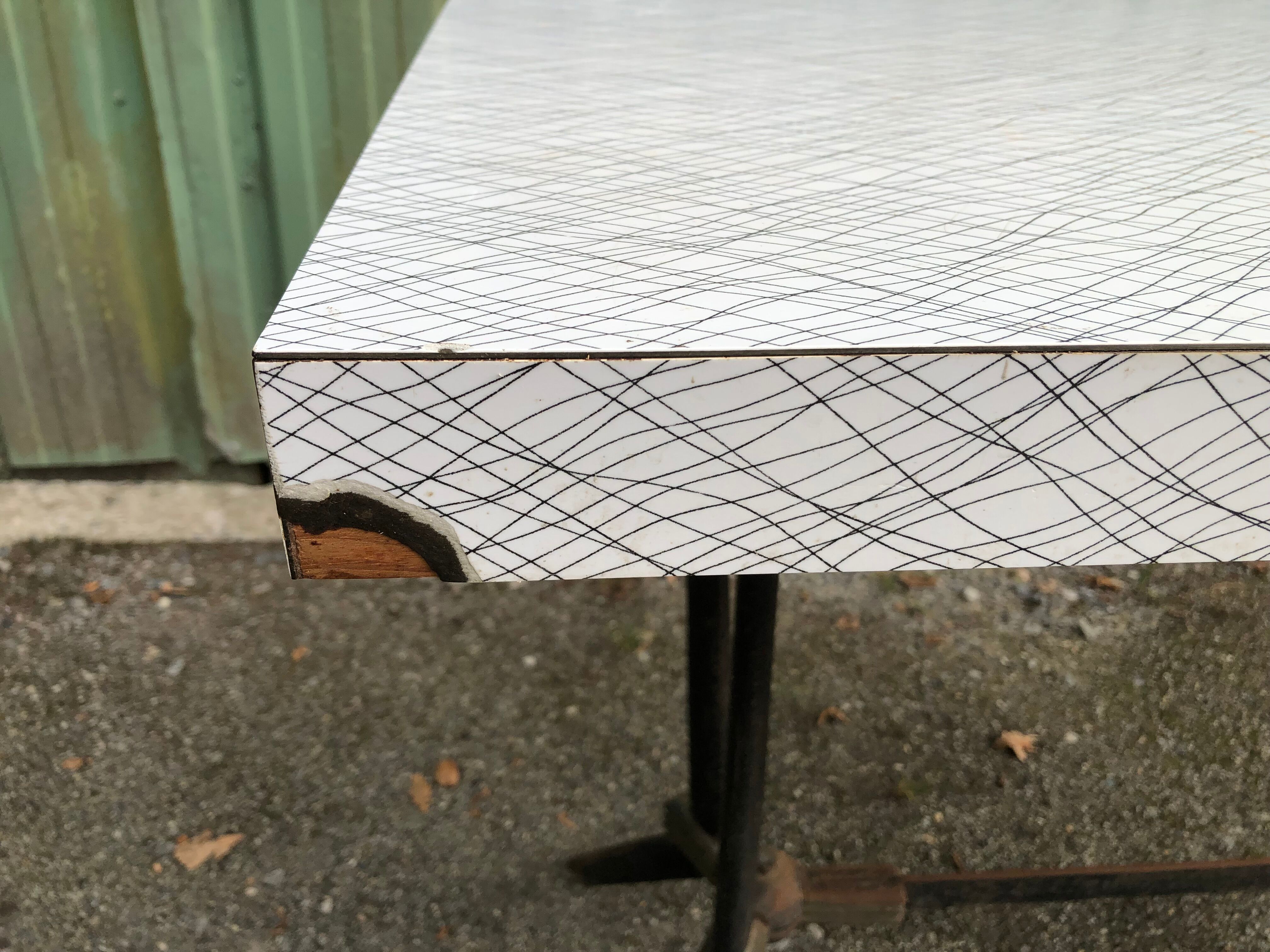 Vintage bistro table with an Art Deco style cast iron base and Formica top.