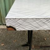 Vintage bistro table with an Art Deco style cast iron base and Formica top.