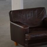 Pair of modern Danish lounge chairs in dark brown leather and rosewood, 1960s.