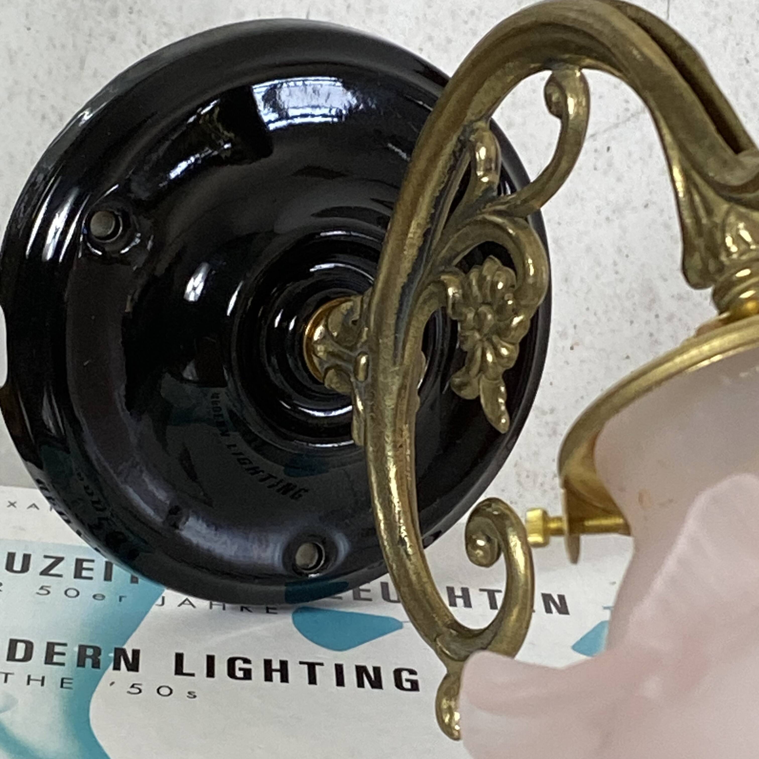 Swan neck wall light in brass with rose petal glass shade.