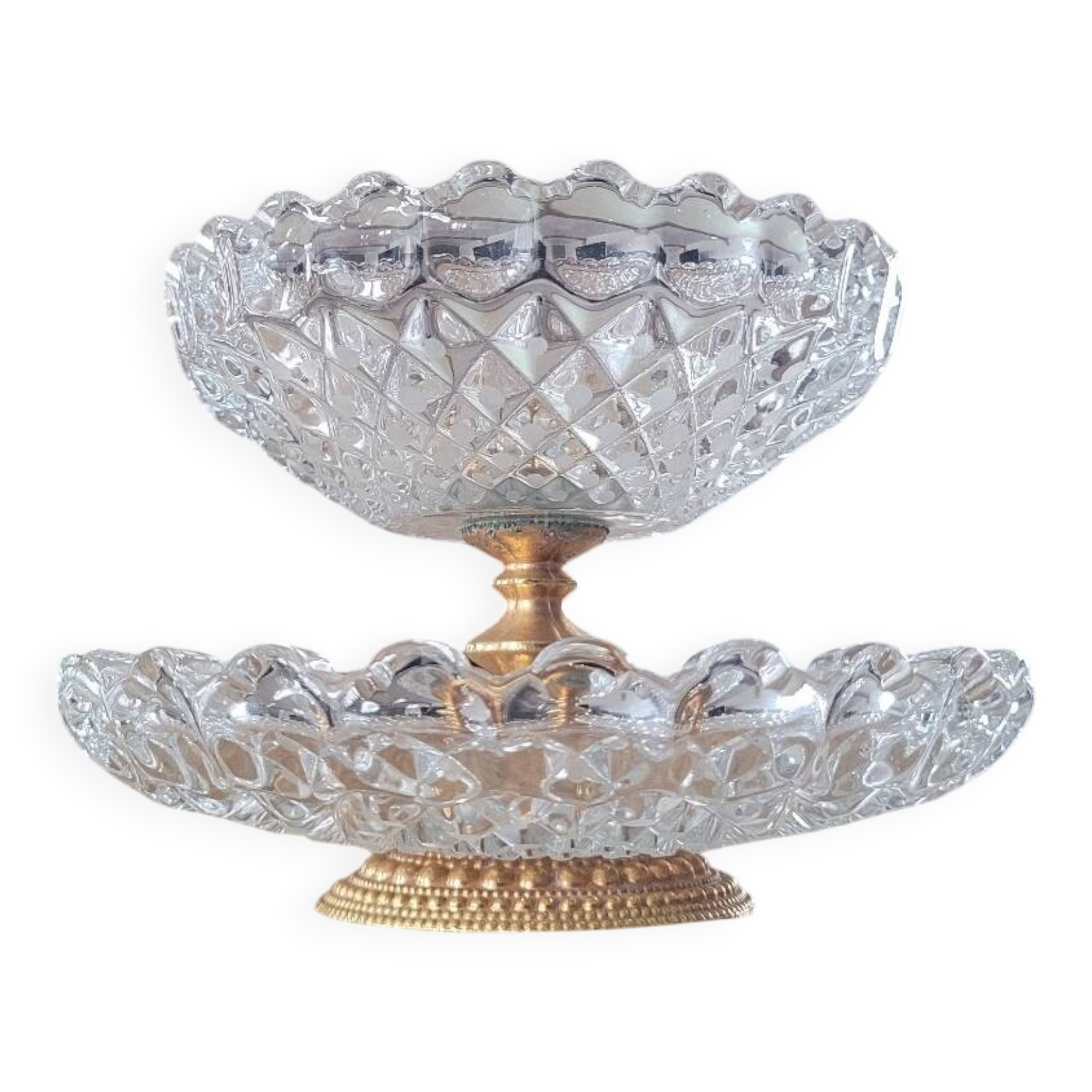 Two-tier display stand in cut glass mounted on a gold metal base.