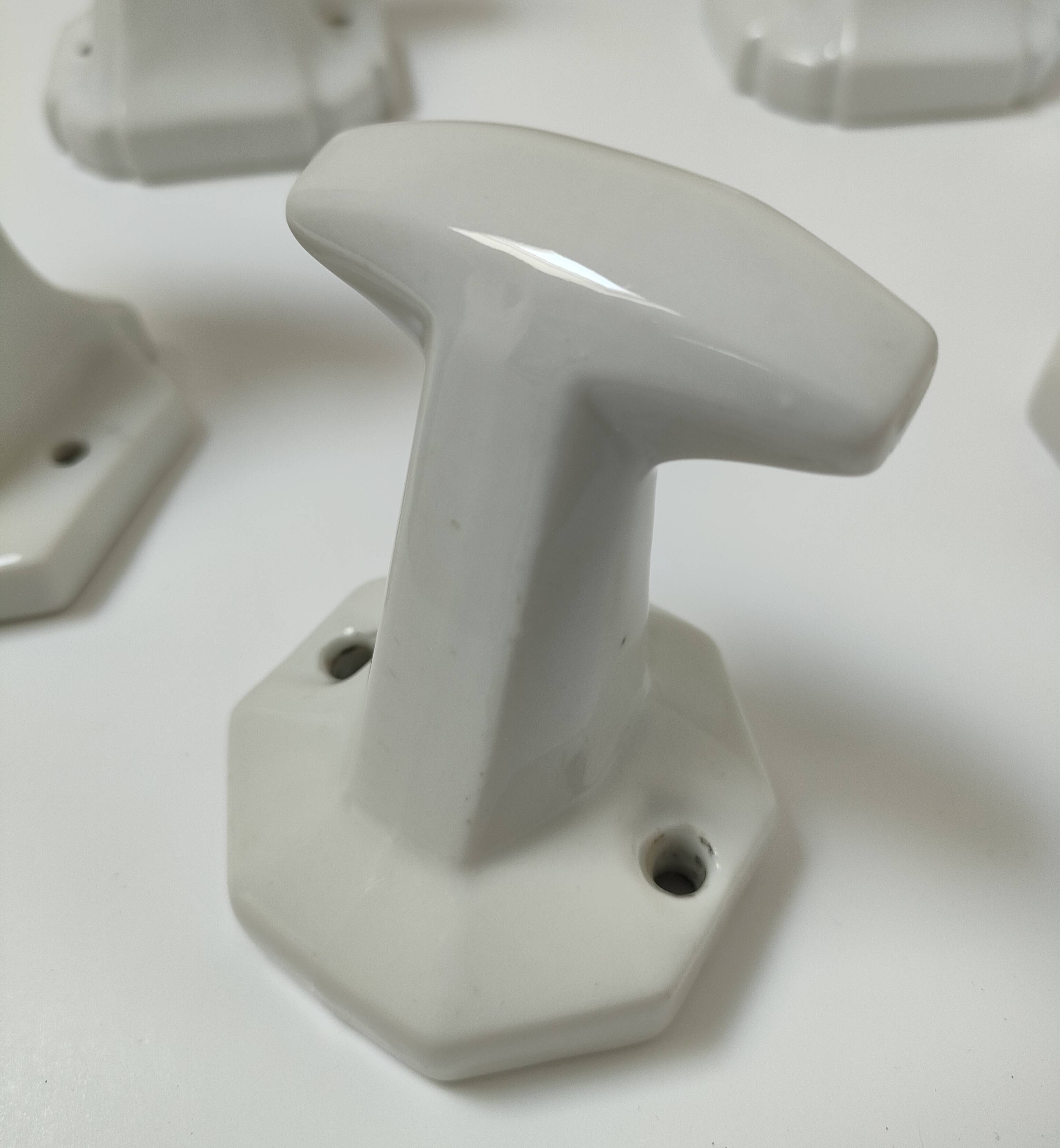 Five art deco white porcelain hooks