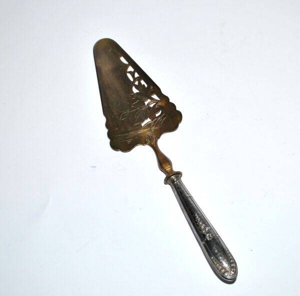 Antique silver-plated pie server with a brass blade decorated with roses.