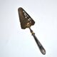 Antique silver-plated pie server with a brass blade decorated with roses.
