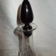 Dark purple glass wine carafe with a stopper.