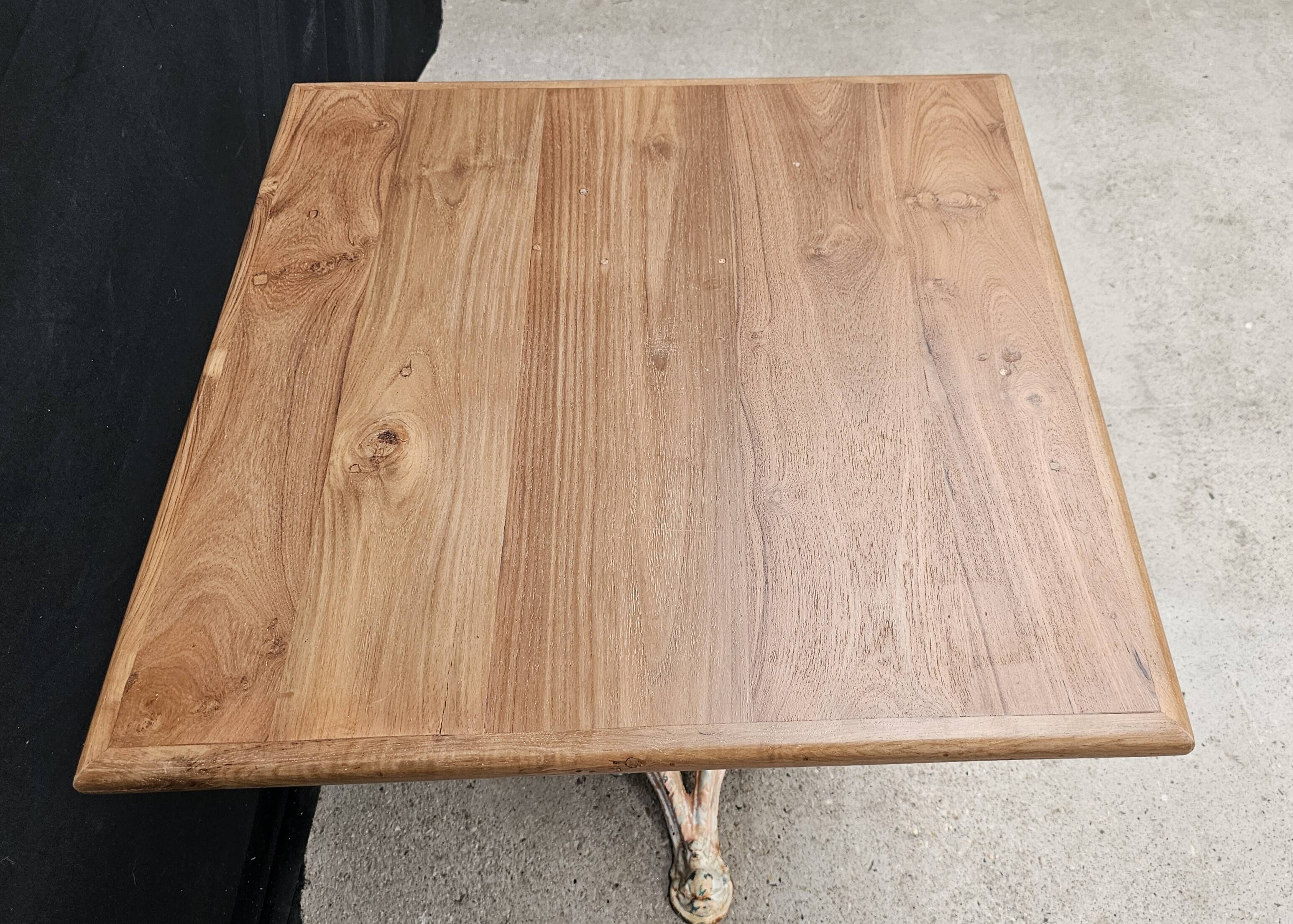 Bistro table with cast iron base and solid teak top