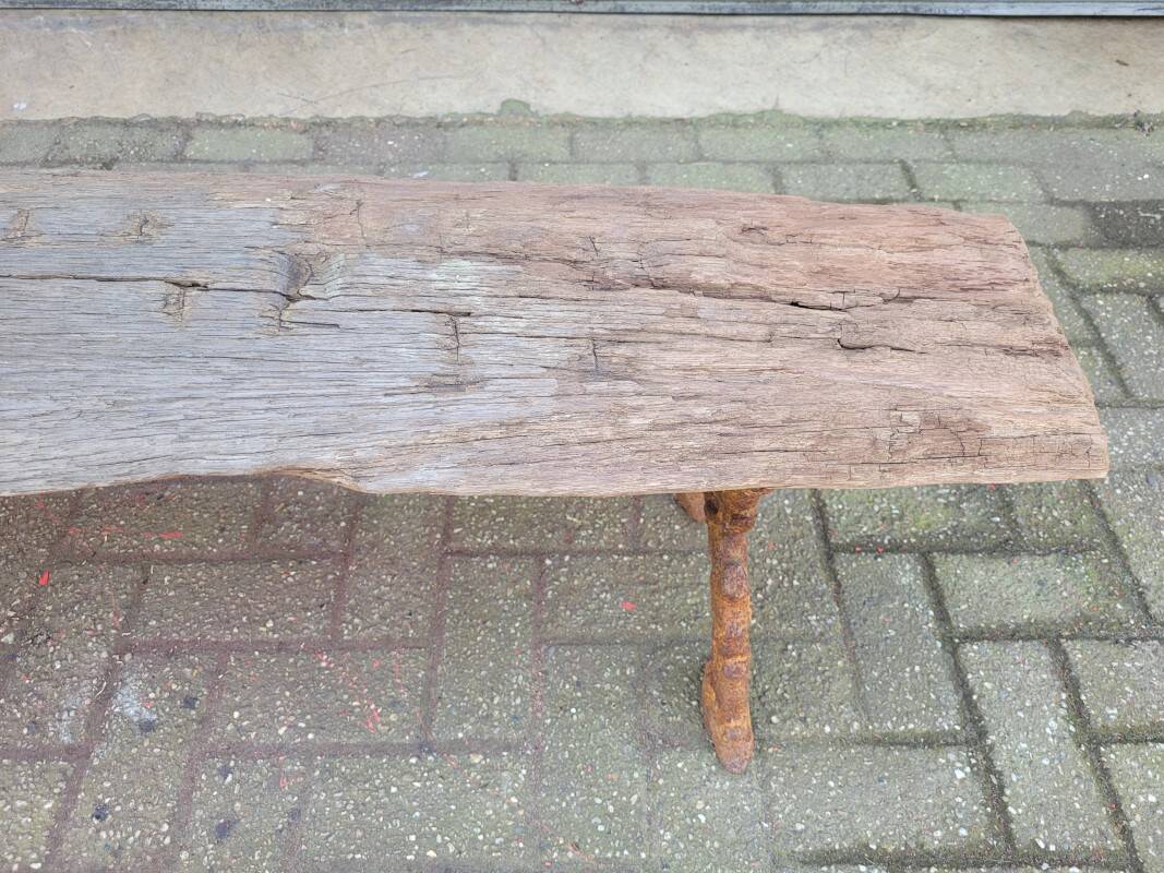 French country style cast iron bench with old rustic wooden plank