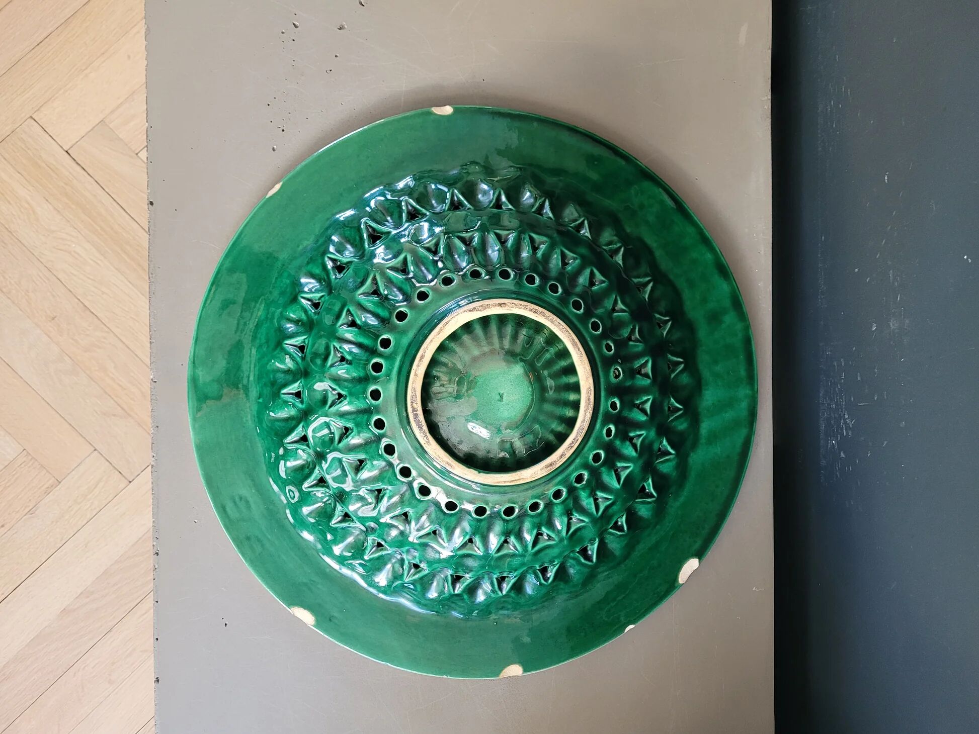Large pierced earthenware fruit bowl glazed in green and gold.