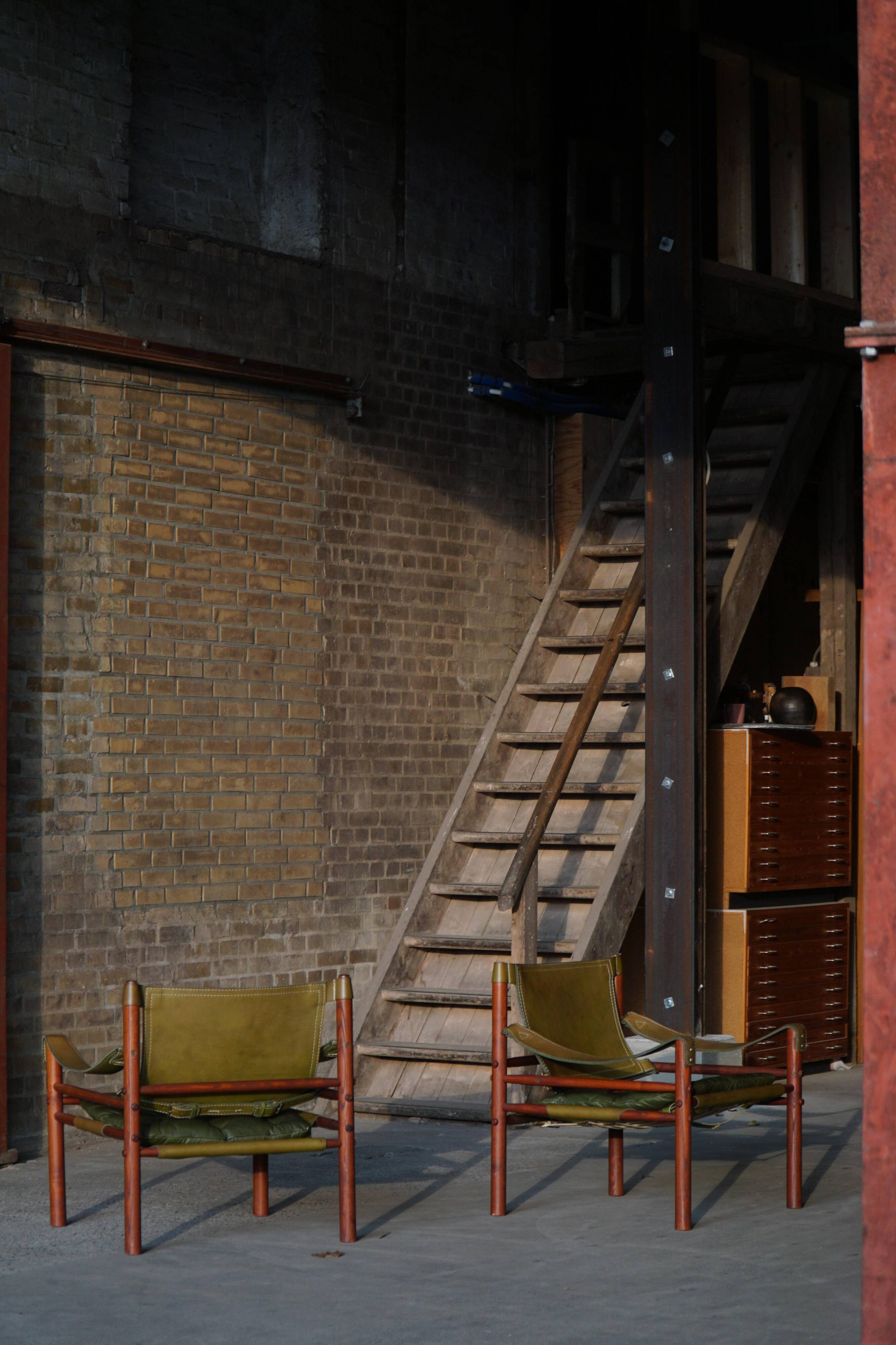 Arne Norell, Pair of "Sirocco" Safari armchairs in ash and green leather, 1960s.