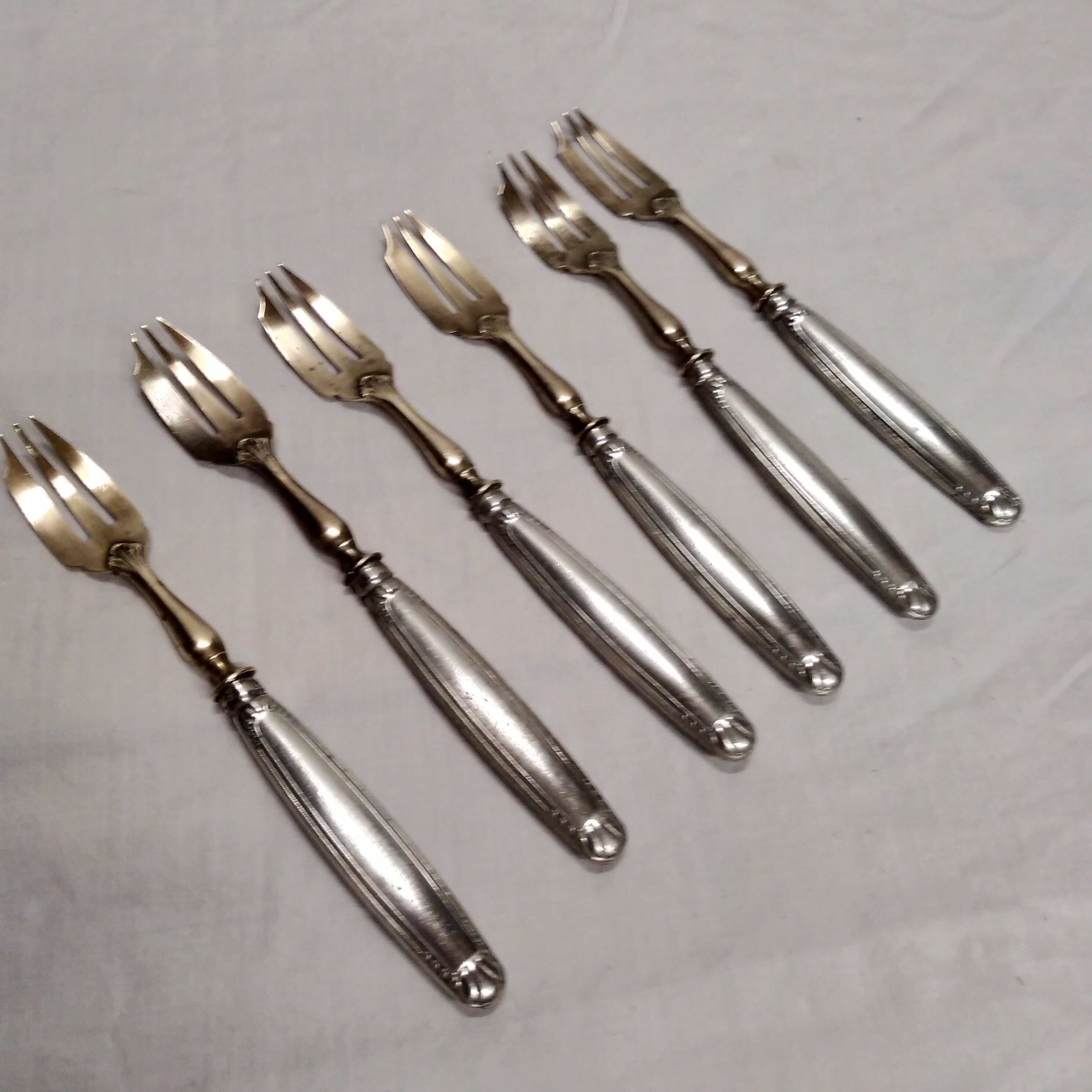 Silver and gold cake fork service