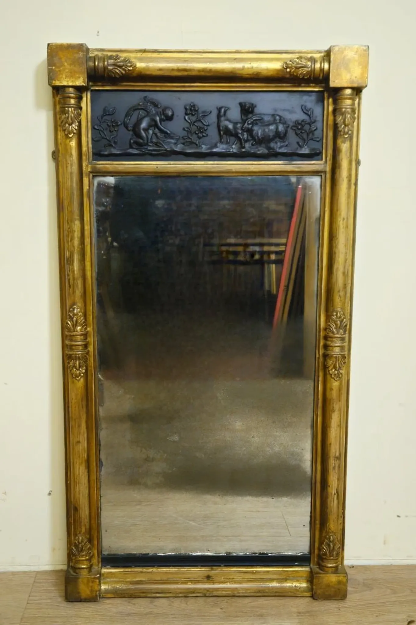 Large antique gilded wooden mirror with terracotta relief from the Empire period.