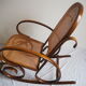 Rocking-chair en bois teinté et assise cannée