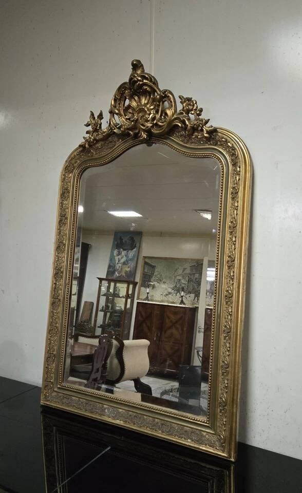 Large carved and gilded wooden mirror, rectangular in shape.