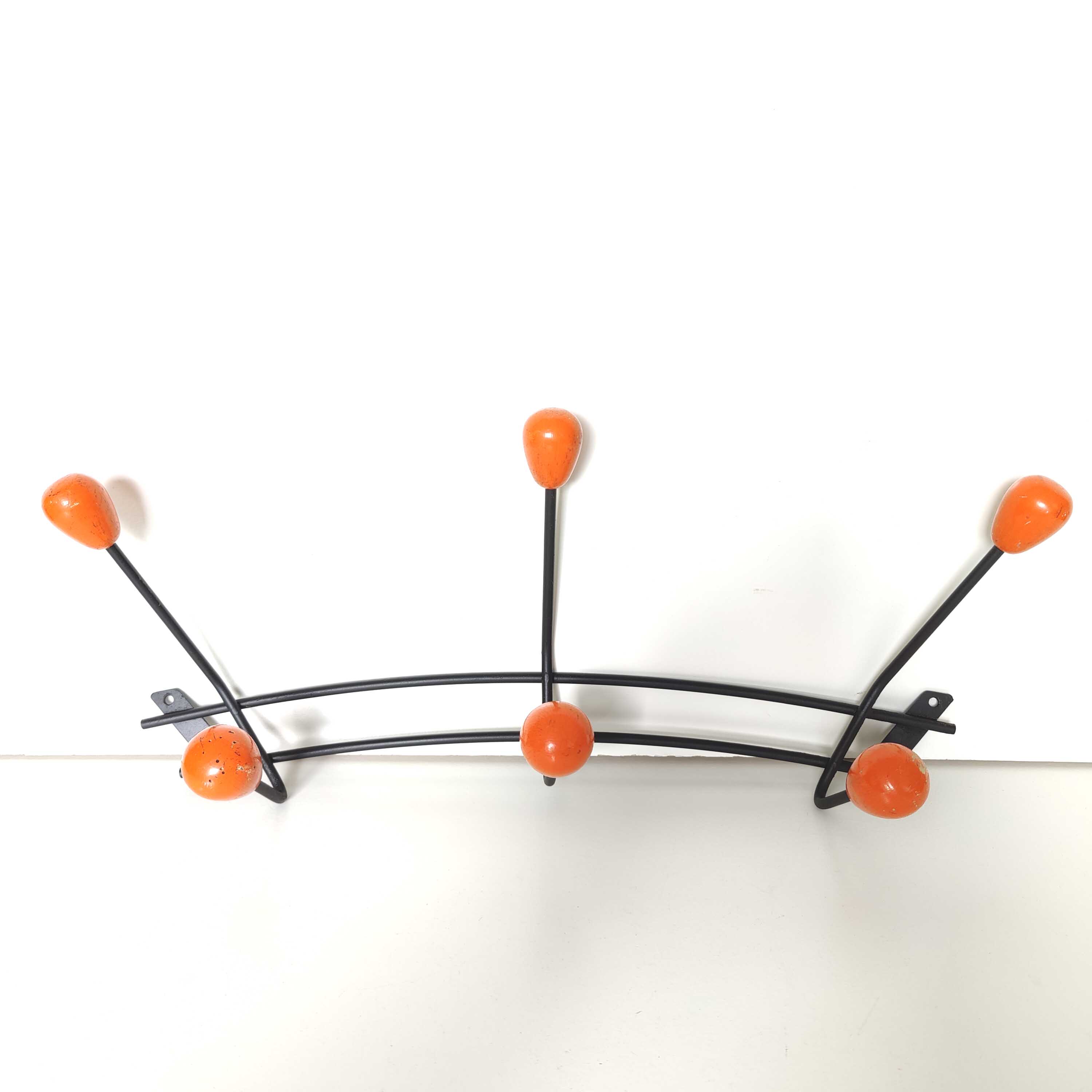 Black metal coat rack and orange wood balls