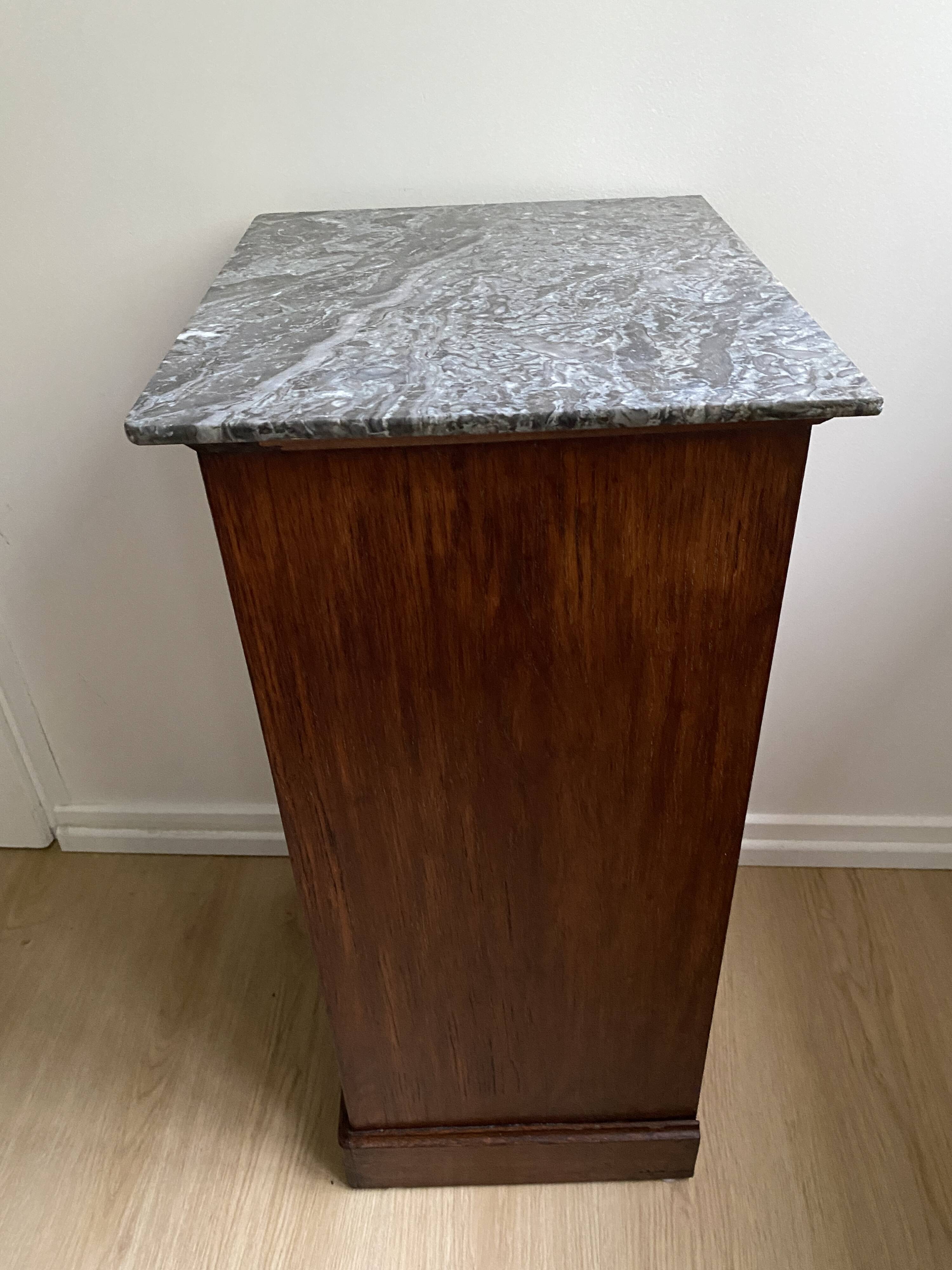 Vintage bedside table in the shape of a wooden column and a gray marble top