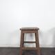 Brown painted wooden workshop stool with a patinated top.
