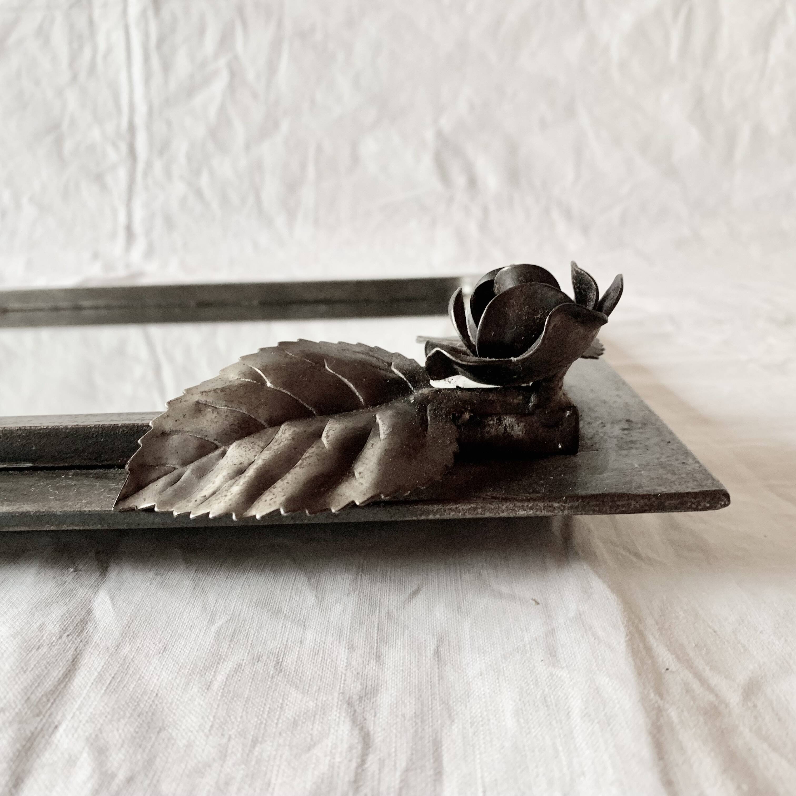 Vintage wall mirror in varnished steel decorated with a rose in relief