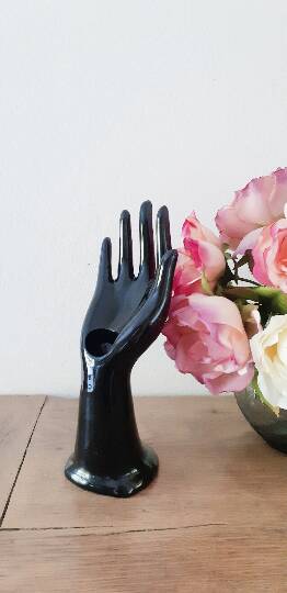 Hand holds black jewelry, ring sizer, soliflore, vintage French, 50s