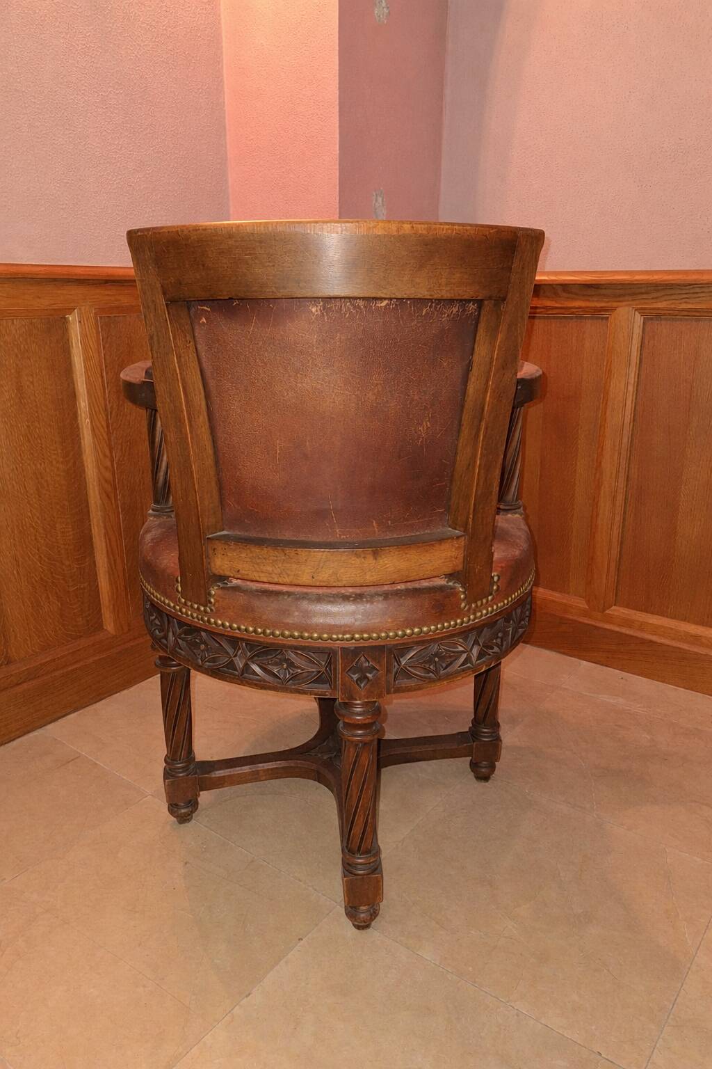 Antique swivel armchair in carved wood and patinated leather – neo-Renaissance style